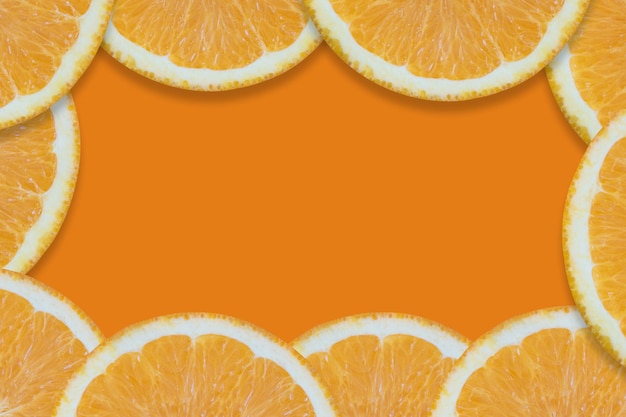 Oranges cut into pieces. Close-up texture. Copy space. Orange background.