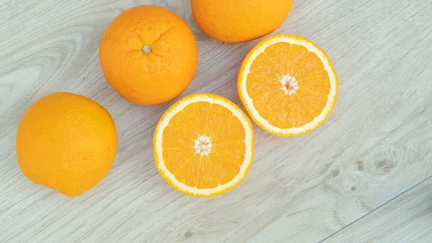 Oranges fruit in a basket on a wooden table.