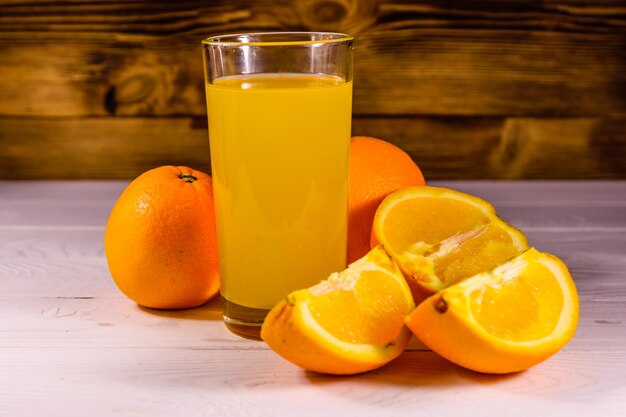 Oranges and glasses with orange juice on a wooden table