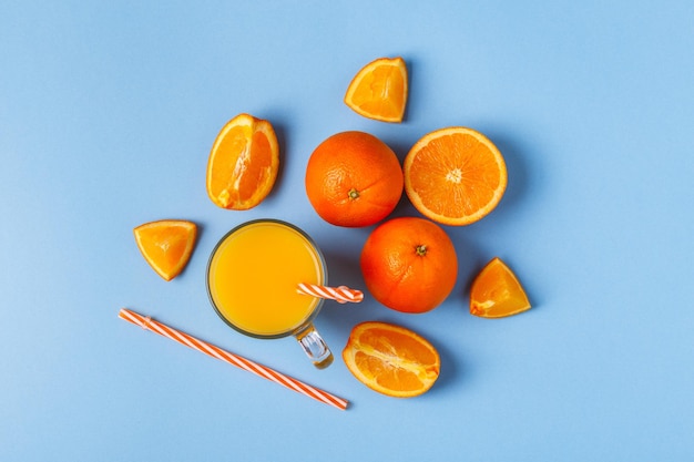 Oranges and juice on a blue pastel background