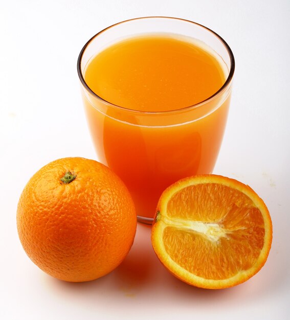 Oranges and juice in a glass white surface