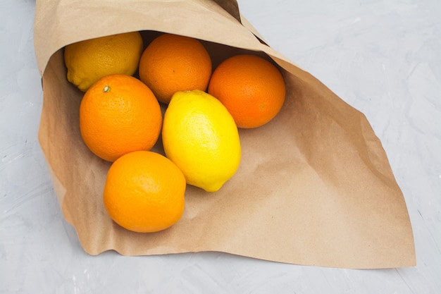 Foto arance e limoni in imballaggi di carta ecologica.