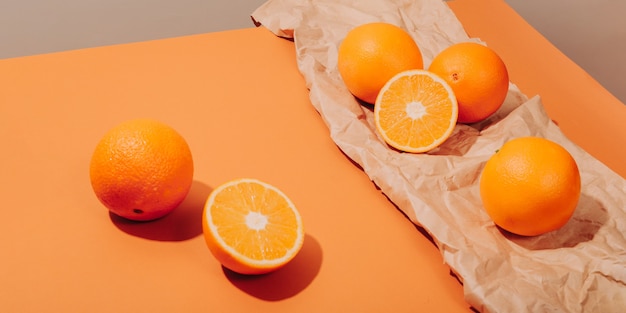 Фото Апельсины разбросаны на имбирном столе на фоне мятой крафт-бумаги.