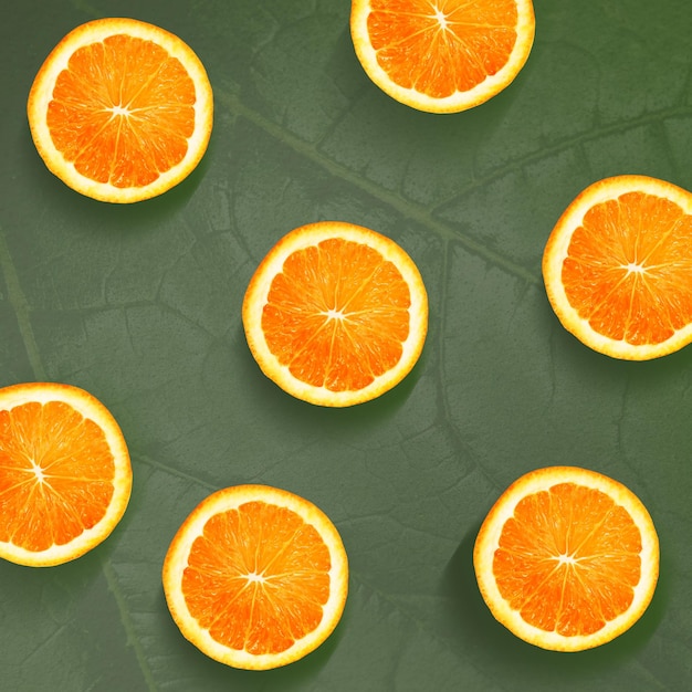 Oranges slices pattern background, fresh fruits on green background