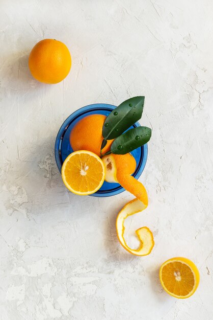 Oranges with leaves on a blue plate