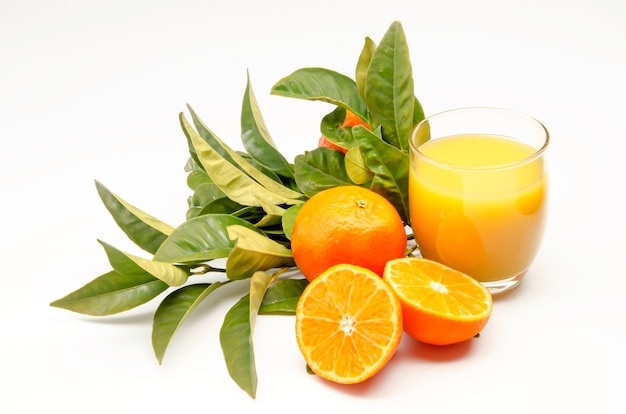 Oranges with leaves and orange juice on white