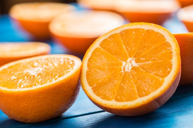 Oranje. Bovenaanzicht gesneden verse sinaasappelen op een blauwe tafel.