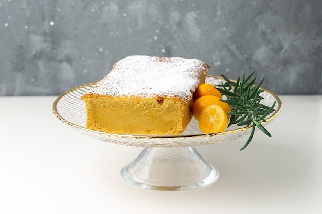 Oranje cake op caketribune met kumquats