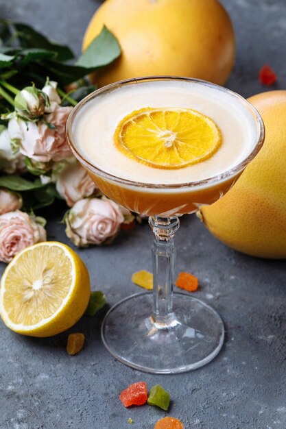 Oranje cocktail met een schijfje sinaasappel op een zwarte betonnen ondergrond Zomer cocktail concept met decor