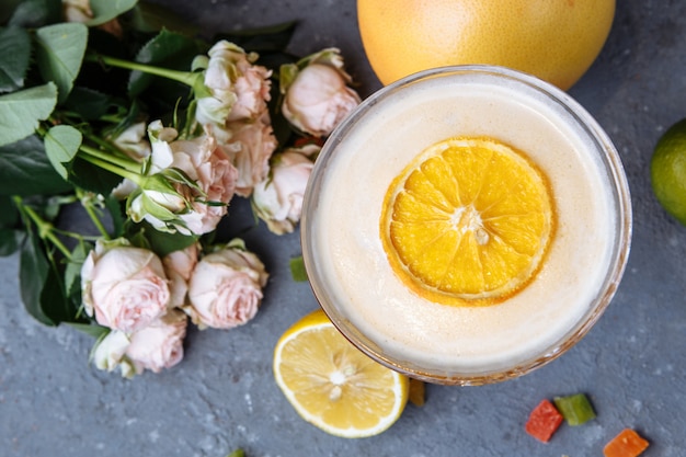 Oranje cocktail met een schijfje sinaasappel op een zwarte betonnen tafel. Zomer cocktail concept met decor