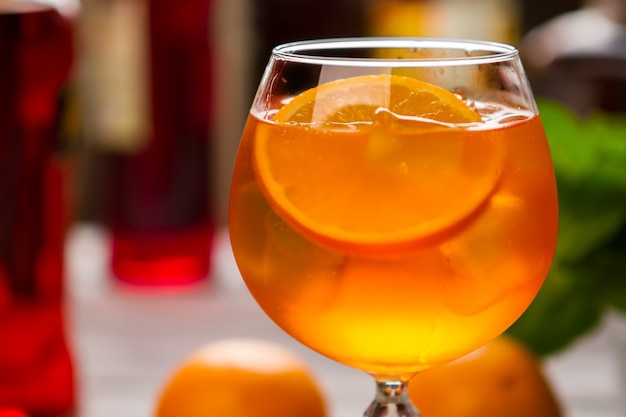 Oranje drankje in wijnglas. Stukje fruit en ijs. Gekoelde aperol spritz. Droge wijn en sodawater.