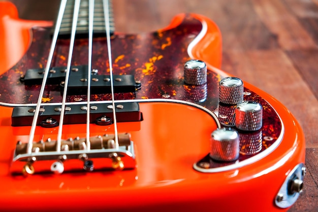 Foto oranje elektrische basgitaar op hout achtergrond met kopie ruimte