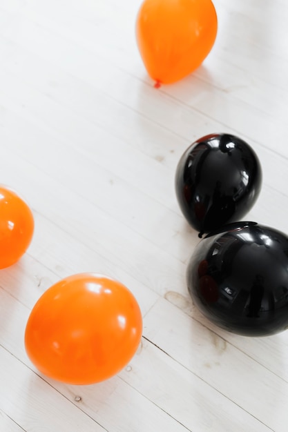 Oranje en zwarte ballonnen op de witte houten vloer