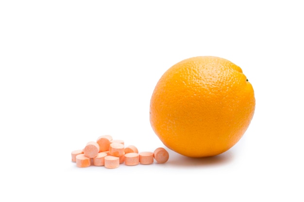 Foto oranje fruit en vitamine c tabletten op witte achtergrond