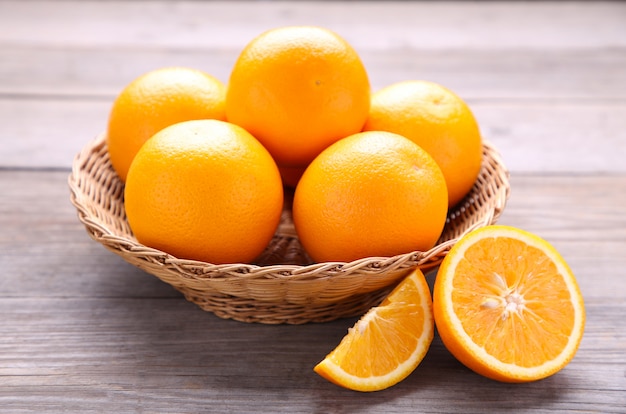 Oranje fruit in mand op een grijze achtergrond