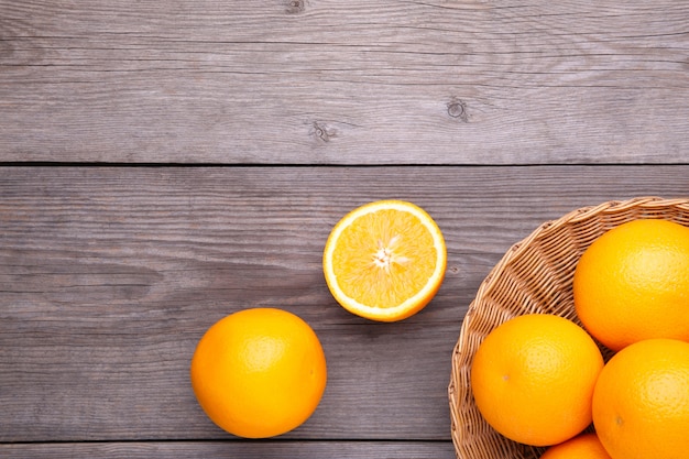 Oranje fruit in mand op een grijze achtergrond