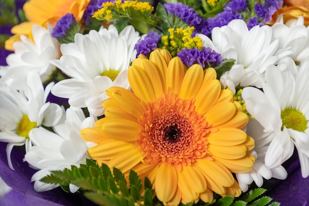 Oranje gerbera en witte chrysant in kleurrijke gemengde bos bloemen