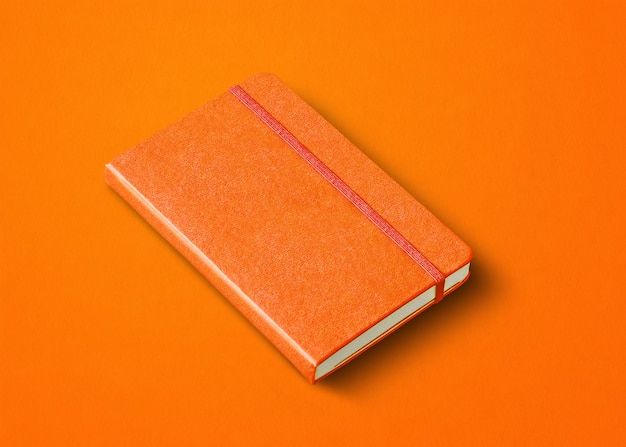 Oranje gesloten notebook mockup geïsoleerd op gekleurde achtergrond