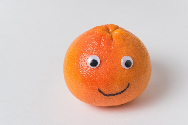 Oranje-glimlach op witte achtergrond. Eten met grappige gezichten. creatief idee.