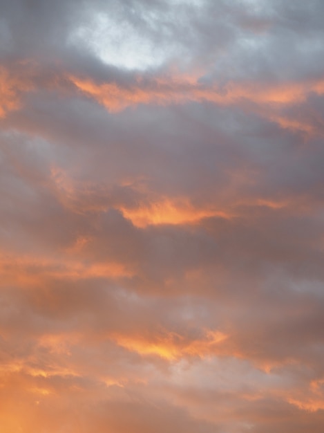 Oranje-grijze wolken bij zonsondergang.