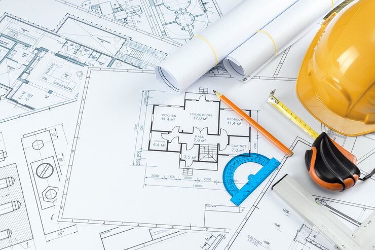 Foto oranje helm, potlood, architecturale constructietekeningen, meetlint