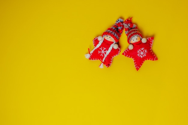 Oranje kerstkaart met speelgoed rode gebreide kerststerren in grappige hoeden. Kerst plat lag.