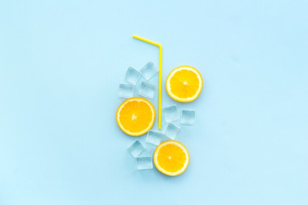 Oranje limonade en ijs op blauwe achtergrond
