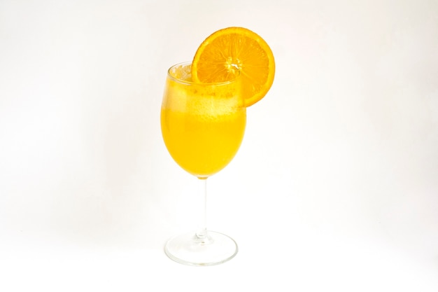 Oranje limonade in een glas met een schijfje sinaasappel, geïsoleerd