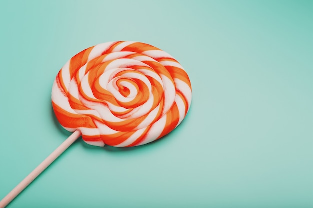 Oranje lolly op blauwe oppervlakte