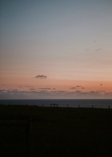 Oranje lucht boven het sombere omheinde strand