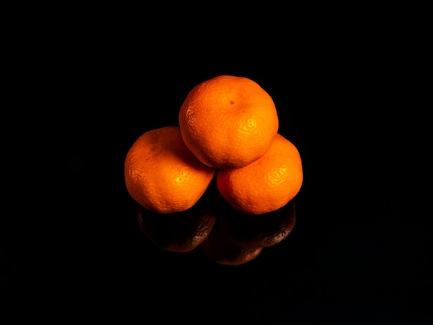 Oranje mandarijnfruit op een zwarte achtergrond