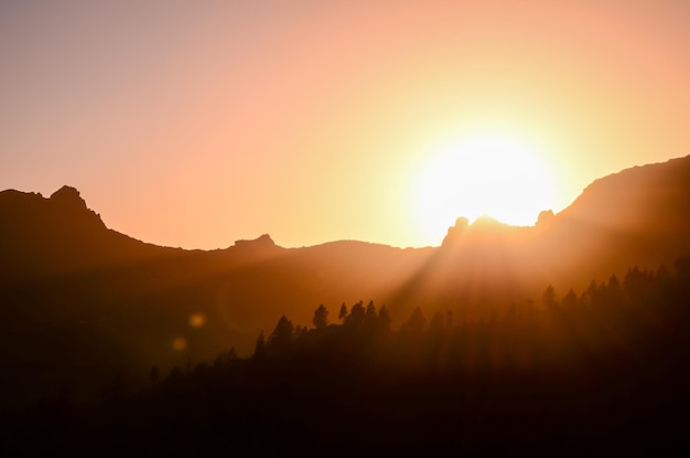 Oranje ondergaande zon achter de bergen