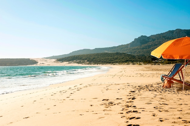 Oranje paraplu op het strand.