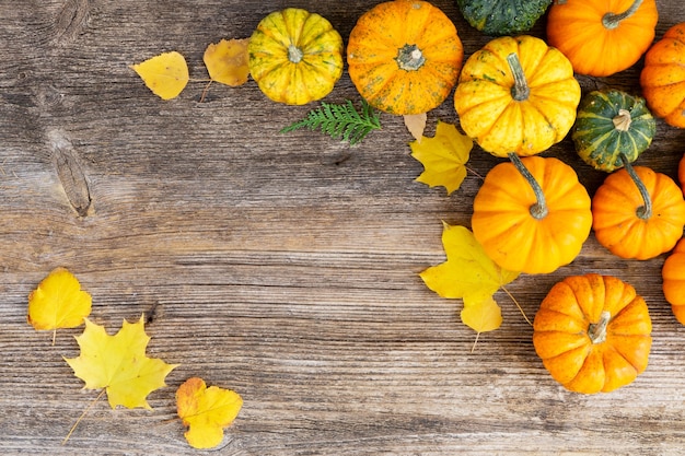 Oranje pompoenen op de oude houten tafel