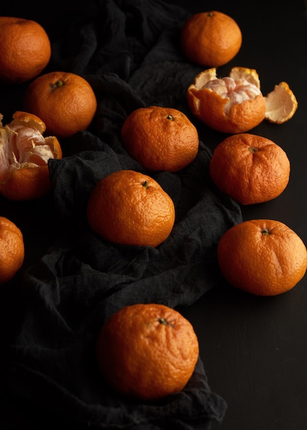 Oranje rijpe mandarijn op een zwarte tafel, rijpe en sappige vruchten