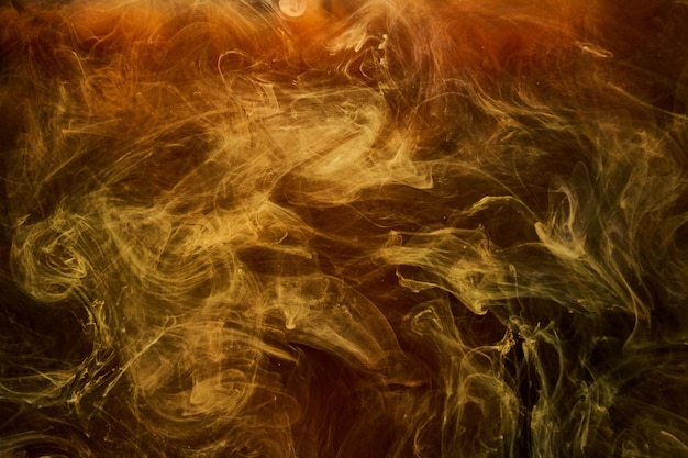 Oranje rook op zwarte inktachtergrond, kleurrijke mist, abstracte wervelende oceaanzee, acrylverfpigment onder water