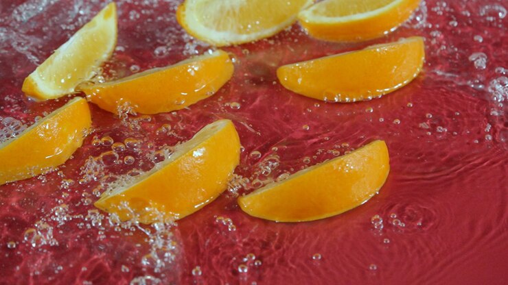 Foto oranje-snijden spetteren in water op een rode achtergrond citrusversoenheid pabulum