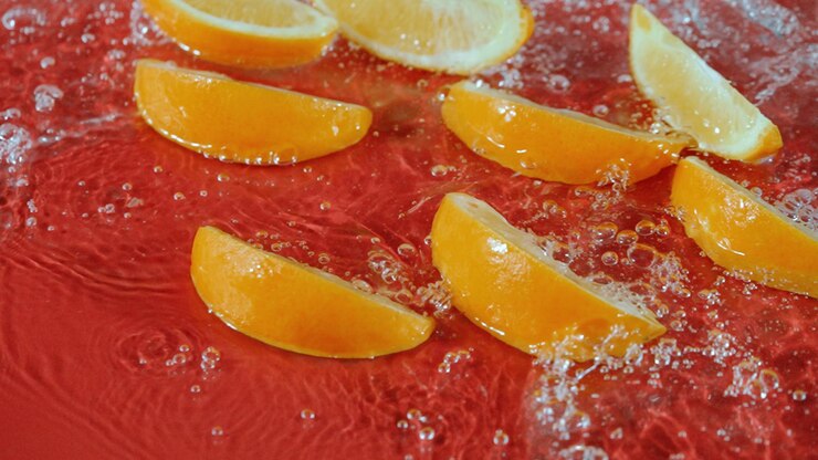 Foto oranje-snijden spetteren in water op rode achtergrond citrus versheid pabulum