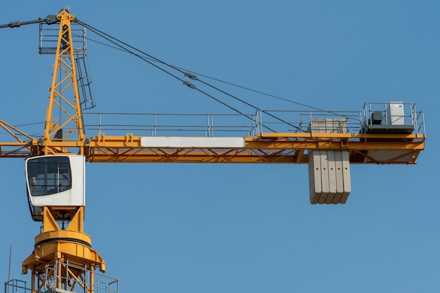 Oranje torenkraan tegen een heldere blauwe hemel bouw van een nieuw bakstenen gebouw moderne bouwplaats woningen op krediet hypotheken verkoop van onroerend goed