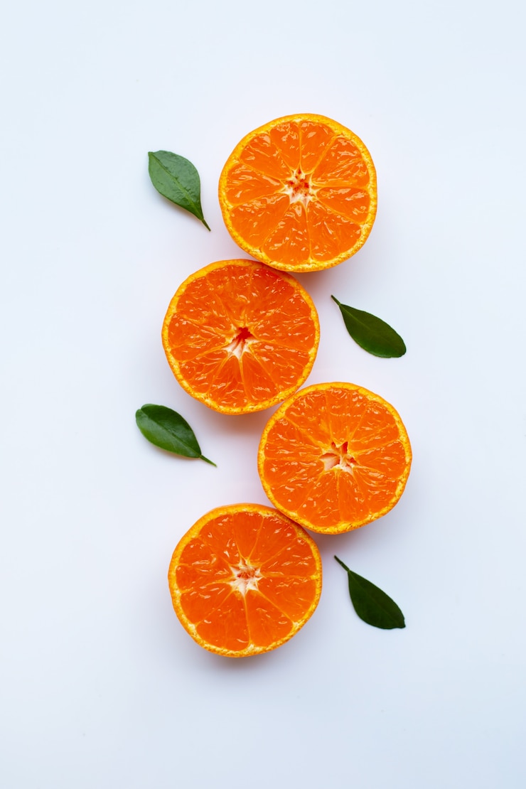 Foto oranje vruchten en groene bladeren op een witte achtergrond.