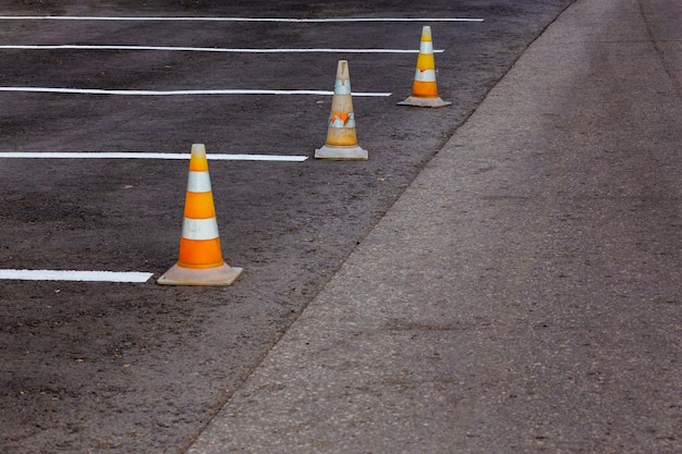 Oranje wegkegels op een asfalt rijgebied met witte lijnen