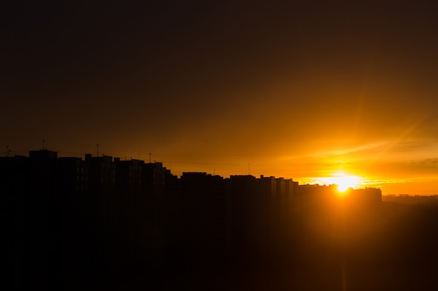 Oranje zonsondergang in de stad. Stadslandschap. Silhouet