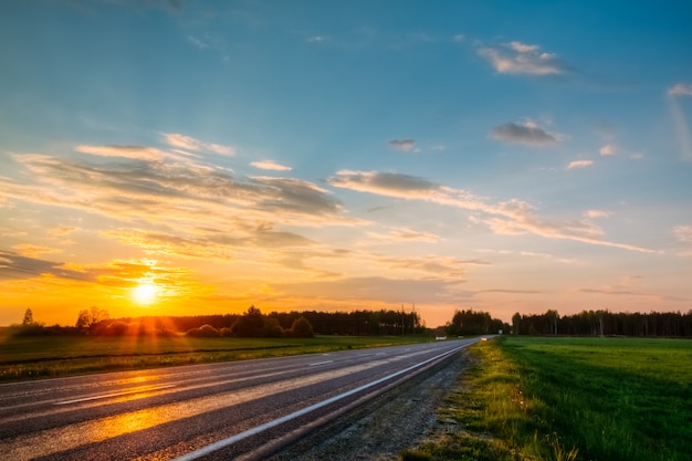 Oranje zonsondergang over het bos en de snelweg. Niemand