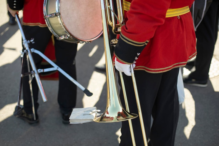 फोटो orchestra member holds brass pipe trumpeter details ceremonial red uniform