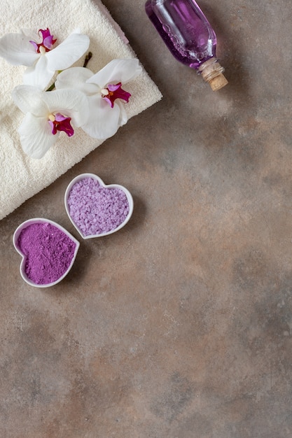 Orchid flower, aroma sea salt, sea mineral essence, natural cosmetic clay, and towel. 