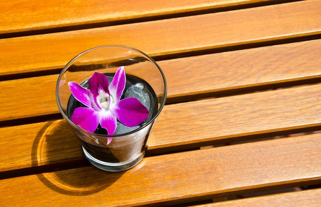 Orchid in glass on table.