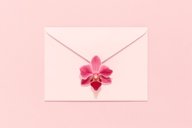Orchideebloem op roze envelop. Felicitatiekaart, Vrouwendag, Moederdag, Valentijnsdag, verjaardag.