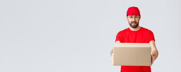 Order delivery online shopping and package shipping concept cheeky handsome bearded courier in red u