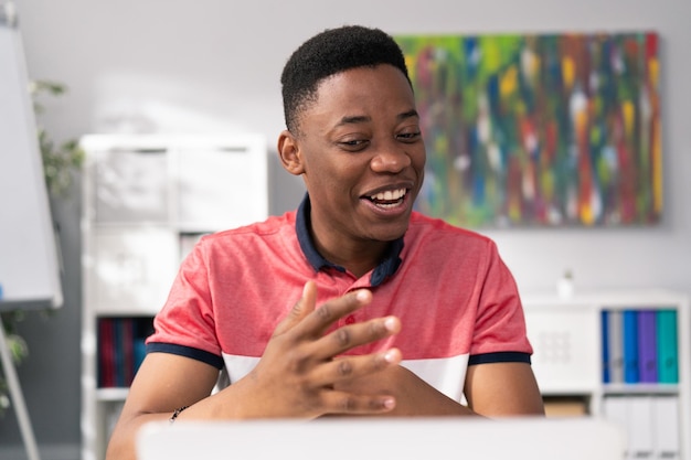 Ordinarily dressed boy with dark complexion black hair and\
brown eyes sits in a room at a table