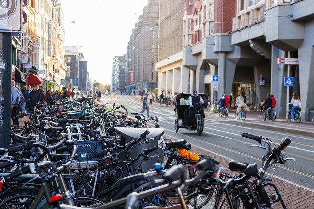 주차된 자전거와 자전거 타는 사람이 있는 평범한 암스테르담 거리, 네덜란드.